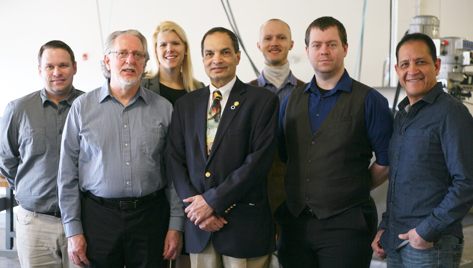 Group of men and a woman in business attire.