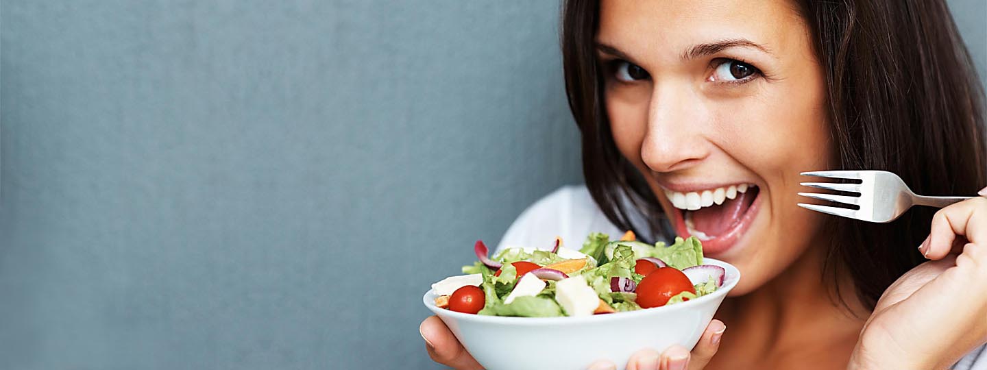 Woman smiling holdng a salad