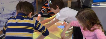 Kids playing in sand with their hands