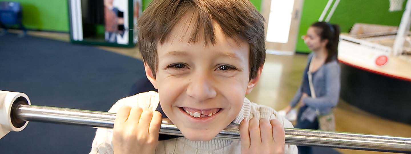 Boy smiling doing pull-ups