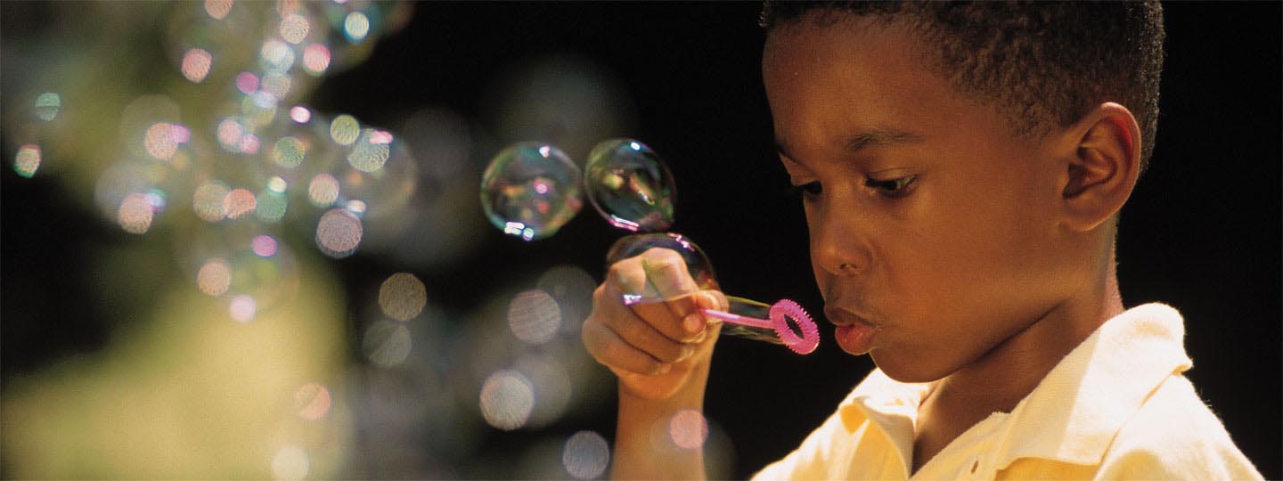 Young boy blowing bubbles