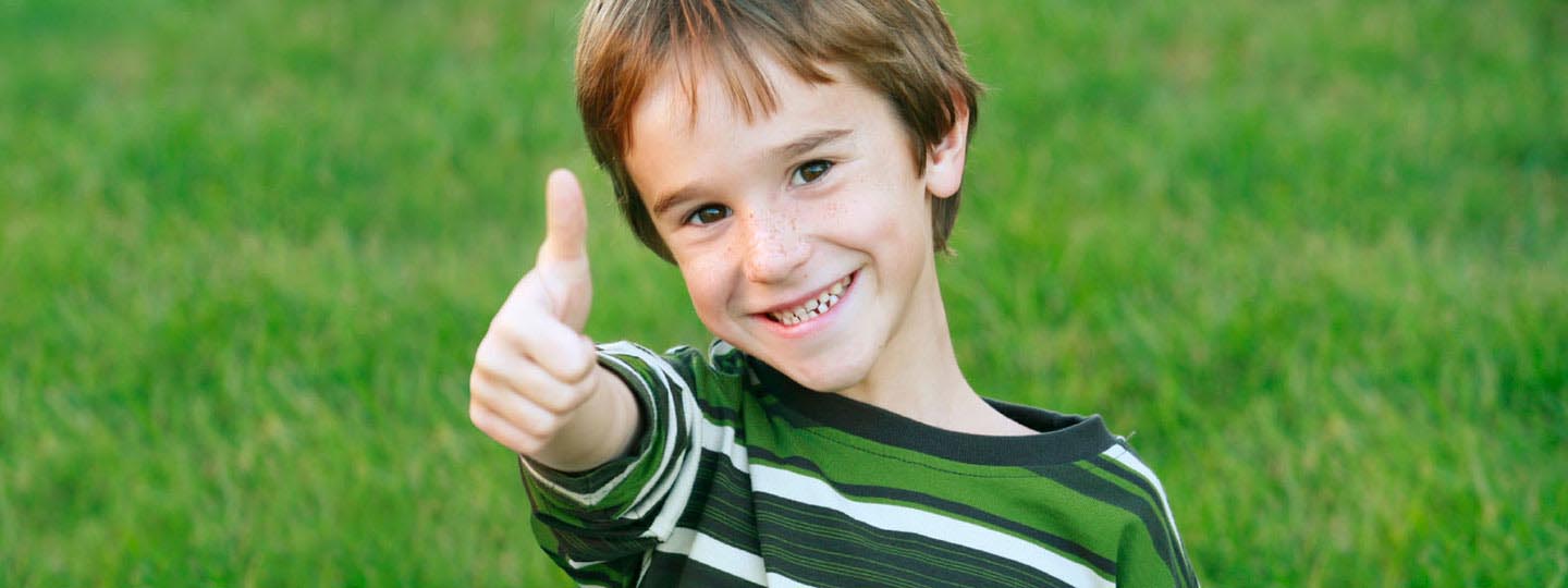 Boy smiling and giving a thumbs up