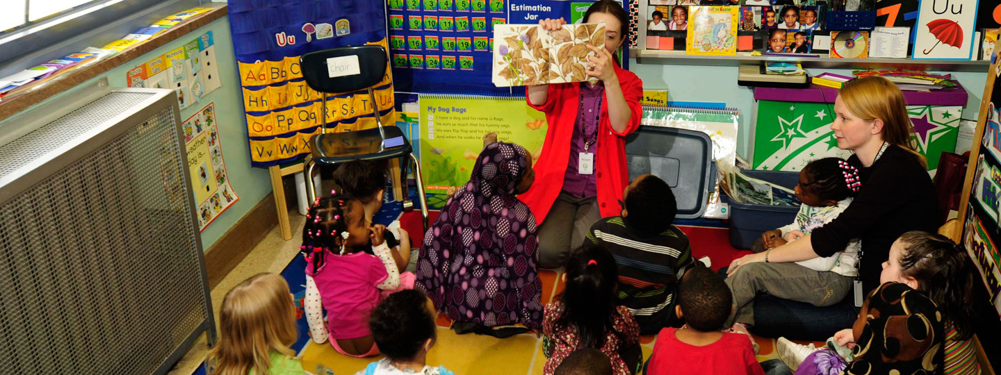 Presenter reading book to young kids